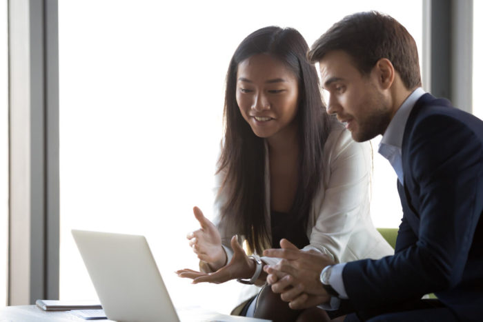 Man and woman looking at laptop computer and talking